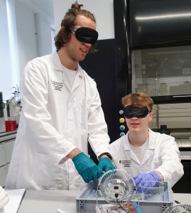 Photo of two students wearing blindfolds to try out an experiment that has been designed to be accessible to people with vision impairment