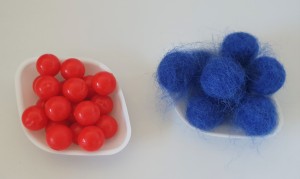 Photo of some smooth plastic red balls and some fluffy wool felt blue balls
